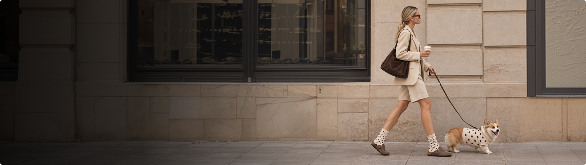 Woman walking her dog in suede clogs and polka-dot socks